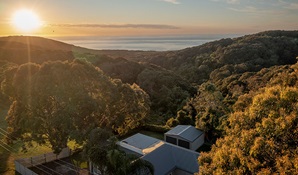 An aerial view of the ocean and Baileys Cottage in Glenrock State Conservation Area. Photo: John Spencer © DPIE